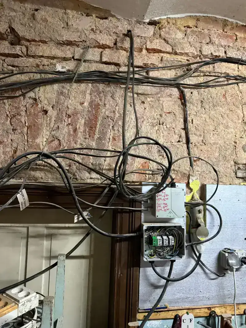 Staré elektrorozvody v cihlovém objektu před opravou